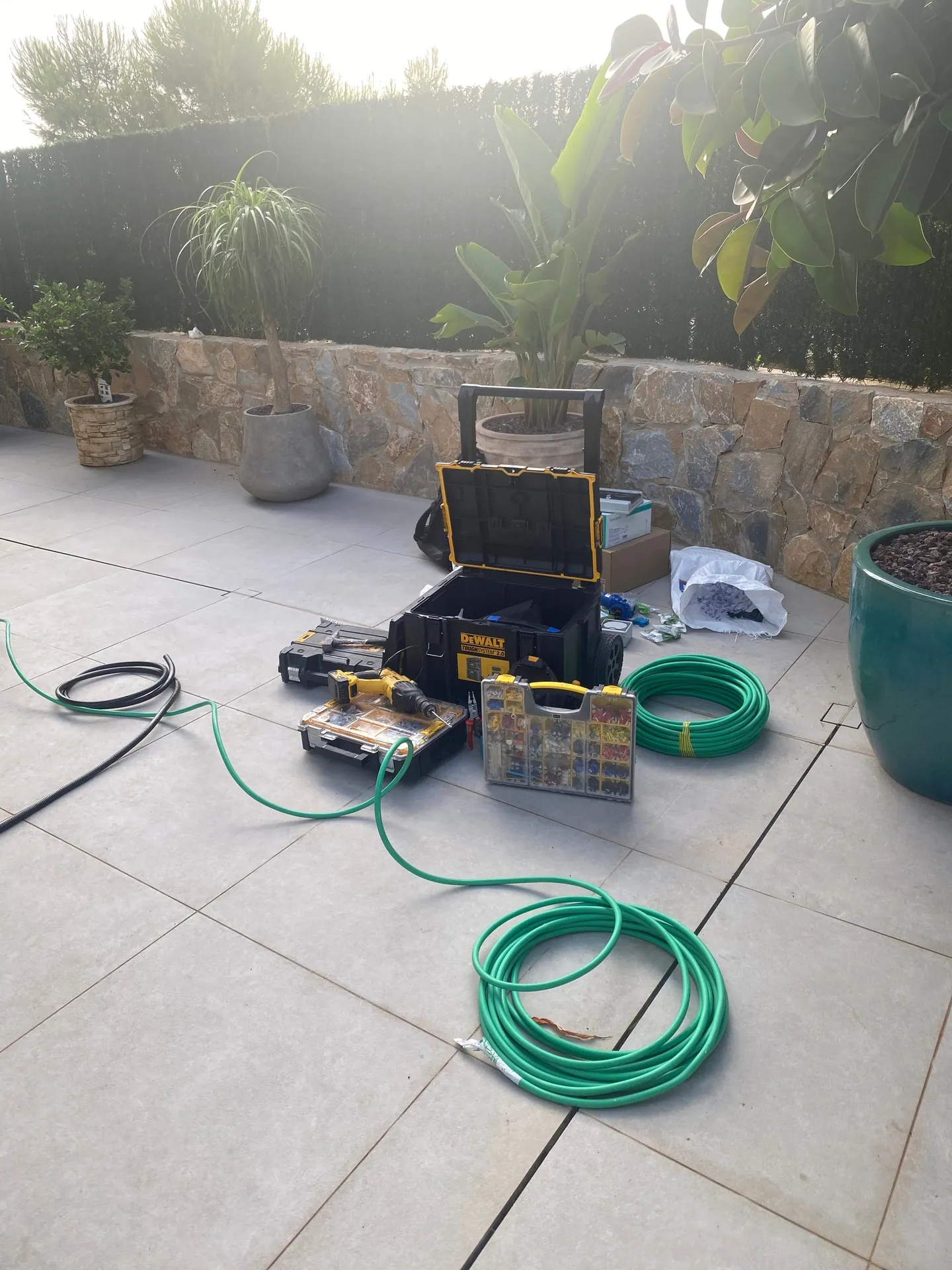 Herramienta y bobinas de cable preparadas en la terraza de una vivienda antes de empezar la instalación