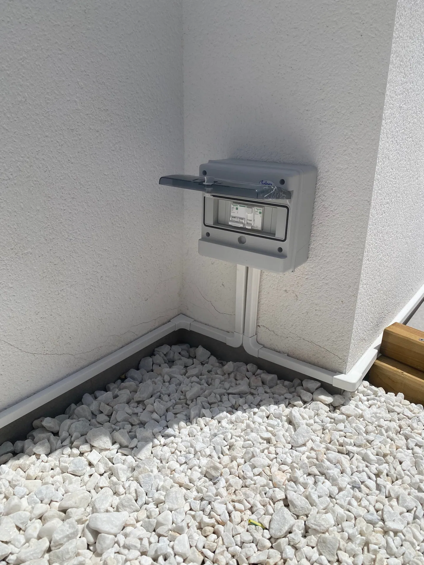Caja estanca de superficie cerrada con dos aparatos de protección y canalización blanca en el rincón